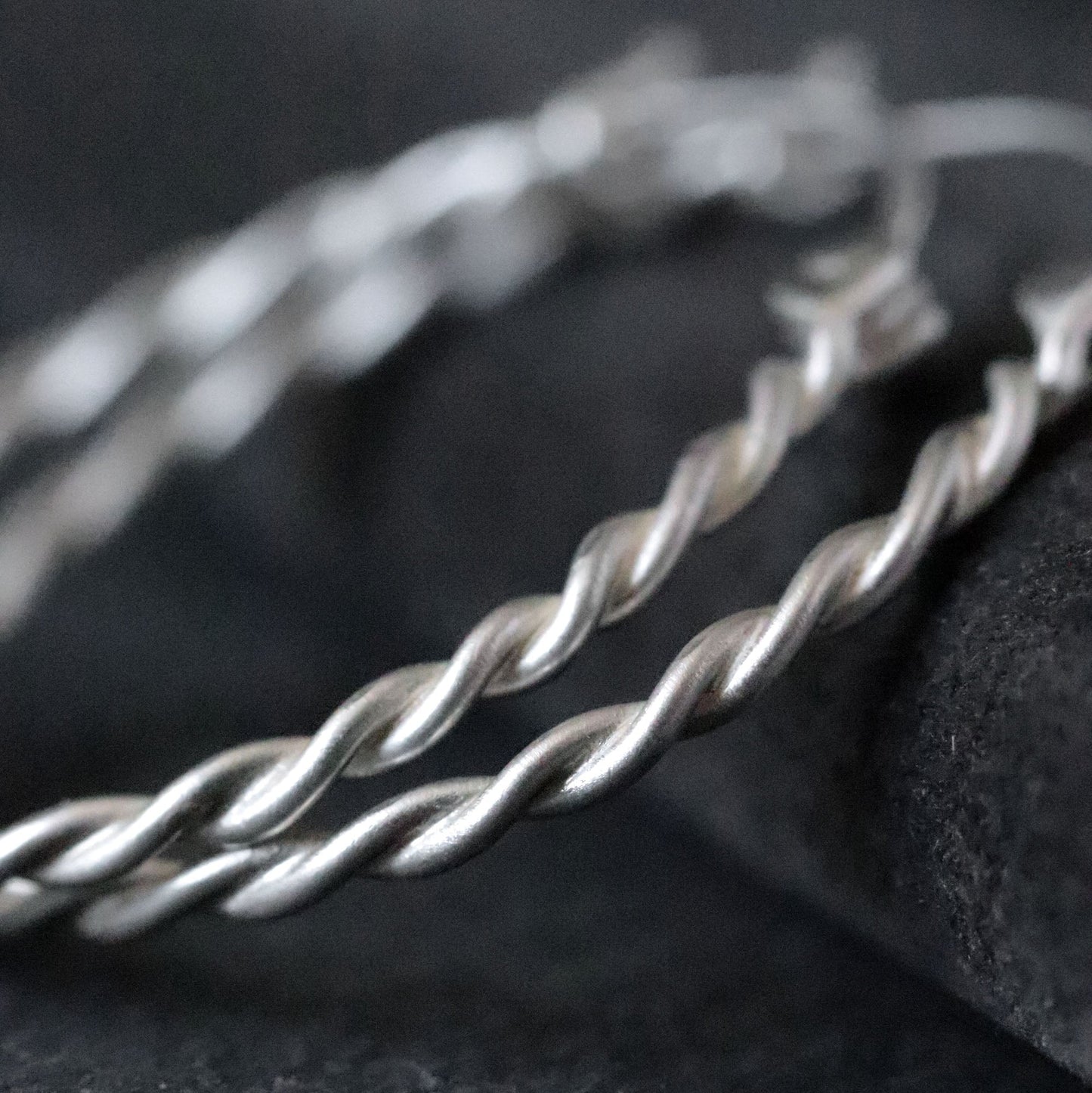 Silver twisted wire on a dark fabric background