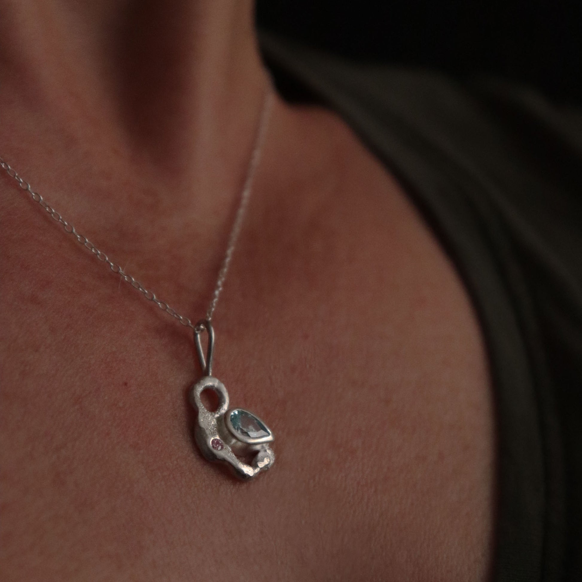 Silver necklace with a pendant on a person's neck